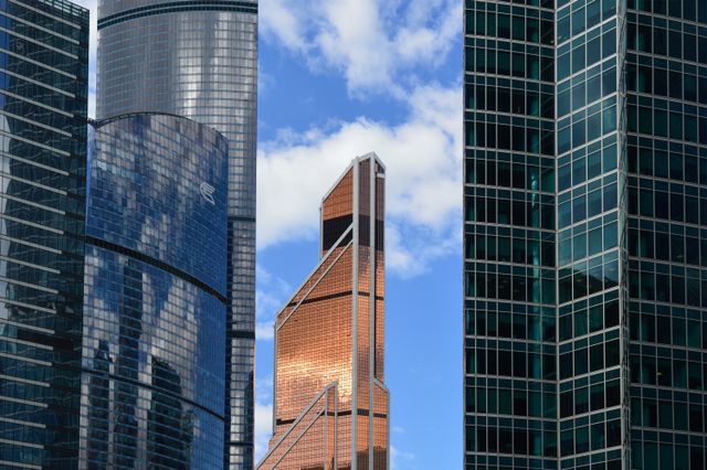 Contemporary skyscrapers with reflective glass facades against a blue sky.